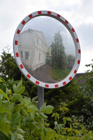 Dewy wet circle street mirror in city after rain