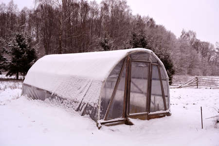 Primitive plastic handmade greenhouse in winter farm gardenの写真素材