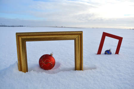 Two Picture frame and Christmas baubles on snow on fieldの写真素材