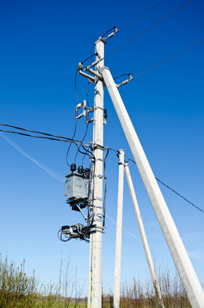 Two electricity pole on farm field in summer