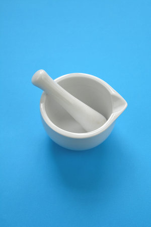 White new porcelain mortar on azure background