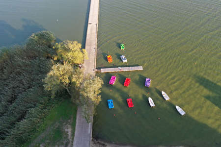 Colorful plastic boats near concrete pier in sea resort, aerial viewの写真素材
