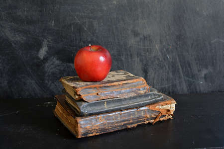 Still life with Old damaged holy bibles and red apple on dark backgroundの写真素材