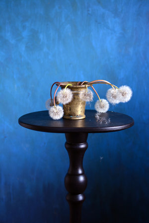 Still life with antique brass Mortar and dried fluffy dandelions headsの写真素材