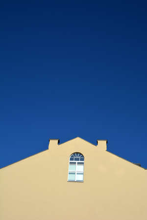 Old wall with lonely window in city and blue sky backgroundの写真素材