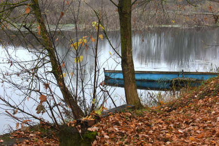 Lake River And Old Wooden Blue Rowing Fishing Boat near coastの写真素材