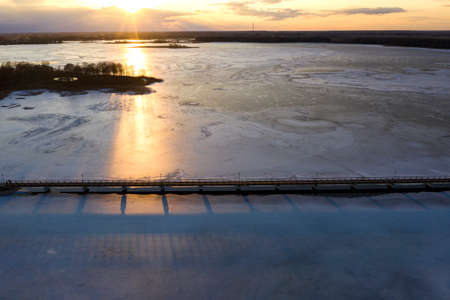 Winter frozen lake with wooden bridge, sunset time, aerial viewの写真素材