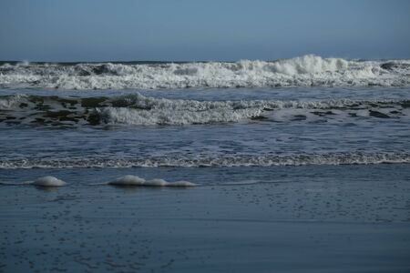 Waves coming in, with the blue sky.  Taken at Hamilton gap beach in Auckland, New Zealand.の写真素材