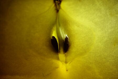A close up of an apple slice with a light behind it.の写真素材