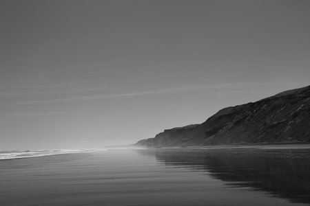 A black and white of the side view of the beach at Port Waikato in New Zealand.の写真素材