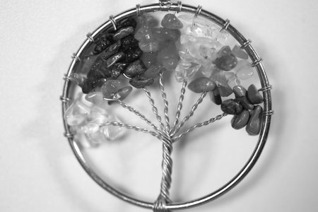 A black and white of a pendant made of wire and beads sharped into a tree.の写真素材