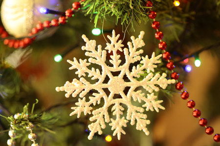 A snowflake decoration hanging on a Christmas tree.の写真素材