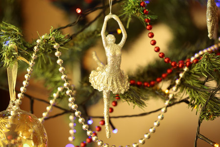 A ballerina decoration hanging on a Christmas tree.