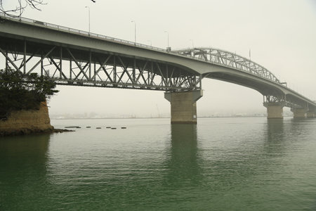 A sideview of the Auckland harbor bridge on a overcast day.の写真素材