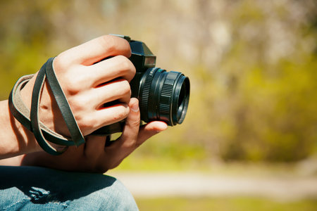 Vintage camera in hand on blurry backround