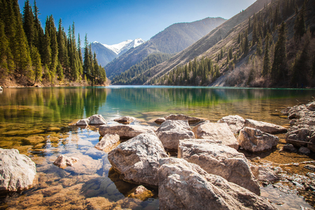 Majestic mountain lake with green trees in Kazakhstanの写真素材