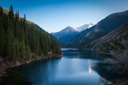 Majestic mountain lake with green trees in Kazakhstanの写真素材