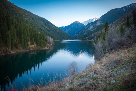 Majestic mountain lake with green trees in Kazakhstanの写真素材