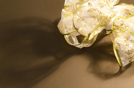 Golden bow on the background of brown surfaceの写真素材