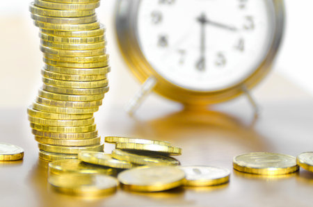 A stack of coins and alarm clock