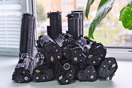 Empty cartridges from the printer stacked on the windowsill of the office. Waste production.の写真素材