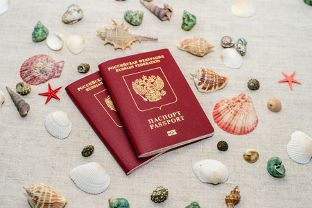 Passport and seashells on the background of sand, travel concept.の写真素材