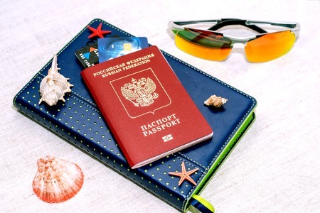 Red russian Passport with bank cards, glasses and seashells. The concept of travelの写真素材