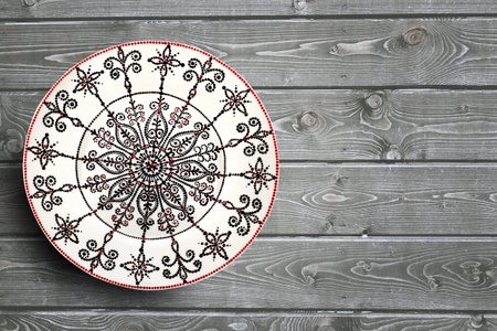 Set of decorative ceramic plates hand painted dot pattern with acrylic paints on a gray wooden...