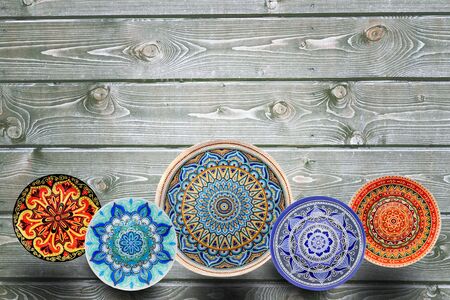 Set of decorative ceramic plates hand painted dot pattern with acrylic paints on a gray wooden background. Copy spaceの写真素材