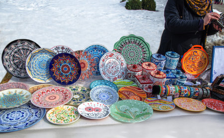 Ceramic plates, hand-painted with a dot pattern, are on the counter at the festive fair
