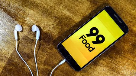 Delivery 99 food. Smartphone with 99 food logo on it. 99 food is a company in the segment of food...