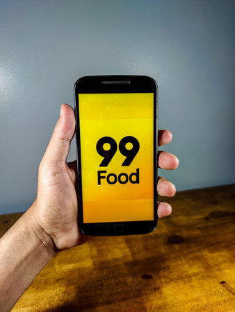 Delivery 99 food. Smartphone with 99 food logo on it.のeditorial素材