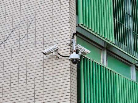 security cameras on pole with building in background.の写真素材