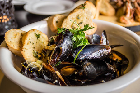 Mussels in shell fried with garlic toastsの写真素材