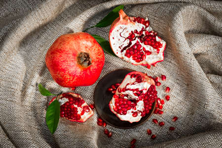 Pomegranate with broken segments - still life on sackcloth backgroundの写真素材