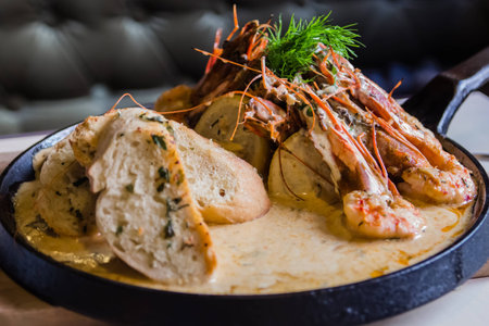 King prawns cooked in sauce with garlic toasts served in panの写真素材