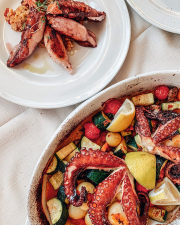 Octopus baked with vegetables and stuffed grilled squid, top view