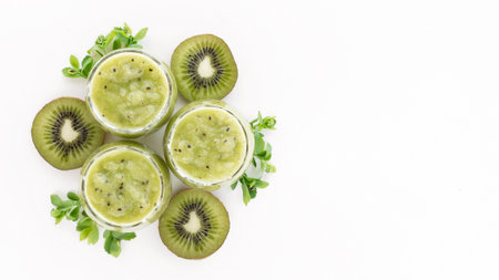 Kiwi smoothie with fresh kiwi slices on white background. Vitamin food creative. Healthy food concept. Copy space.の写真素材