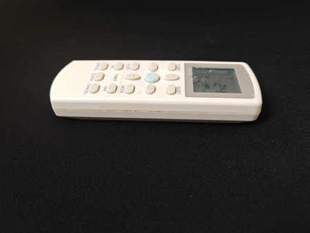 White remote control on a black background, close-up, isolated