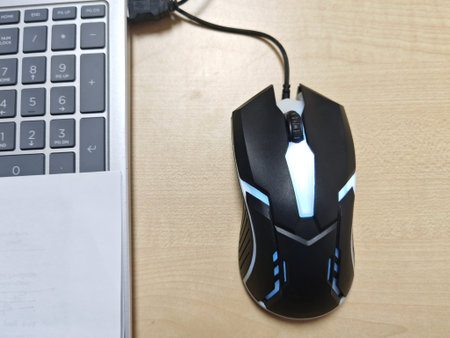 computer mouse with keyboard and mouse pad on a wooden table in the office