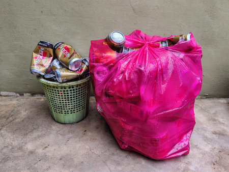 Recyclable Aluminum Cans in Basket and Pink Plastic Bagの写真素材