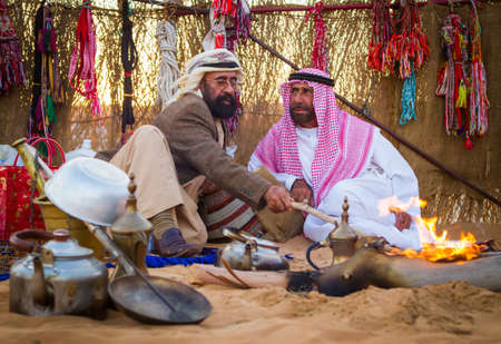 two old emirati men warming themselves with bonfire from cold  in  Al Wathba Festival in Westrin Regin Abu Dhabi on December 9 2012のeditorial素材