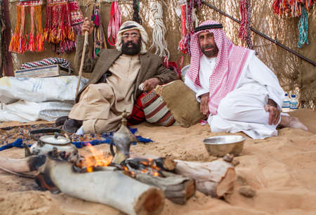 Two old emirati men warming themselves with bonfire from cold  in  Al Wathba Festival in Westrin Regin Abu Dhabi on December 9 2012のeditorial素材