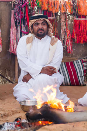 Emirati man warming himself with bonfire from cold  in  Al Wathba Festival in Westrin Regin Abu Dhabi  in Septumber 12, 2012 Abu Dhabi UAEのeditorial素材