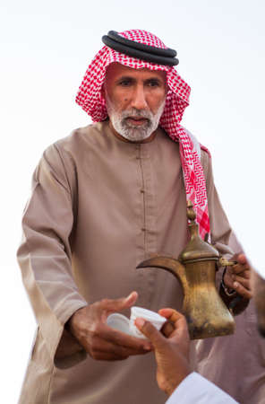 Bedouin man offers arabic coffee in Al wathba festival in September 12, 2014 Abu Dhabi UAEのeditorial素材
