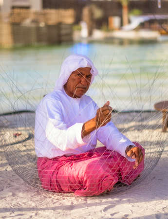Old Man Making Fishing Traps or traditional fishing cages in qasr al hosn festival in Abu Dhabi in February 15, 2015のeditorial素材