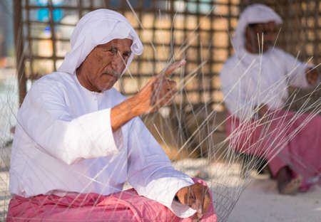 Old Man Making Fishing Traps or traditional fishing cages in qasr al hosn festival in Abu Dhabi in February 15, 2015のeditorial素材