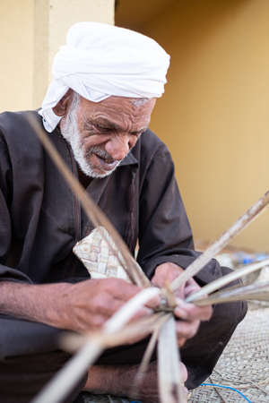 Emirati old man doing palm weaving in n Sheikh Zayed Heritage Festival December 12, 2014 in Abu Dhab, United Arab Emiratesのeditorial素材