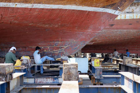 Indian and Bengali Workers repairing old wooden ships and Dhows cruise in Dubai, UAE on 13.10.2014のeditorial素材