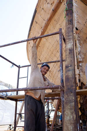 Indian and Bengali Workers repairing old wooden ships and Dhows cruise in Dubai, UAE on 13.10.2014のeditorial素材